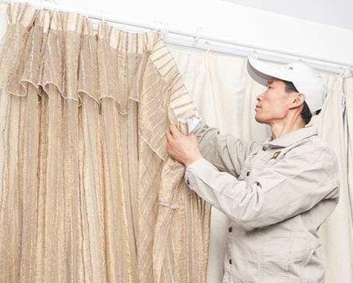 保洁员在拆卸窗帘